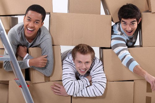 Professional movers carrying furniture through a Ravenscourt Park property