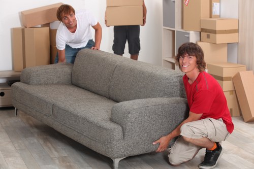 Removal team handling furniture in a West London flat