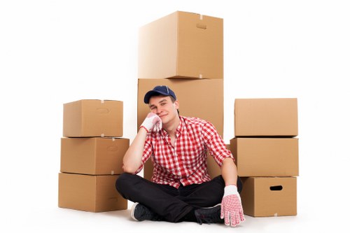 Household relocation scene showing a mover carrying furniture into a new home