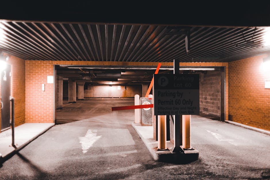 Four blue parking permit signs with white text and symbols are mounted on metal posts in front of a large, vertically ribbed metal wall. The signs indicate parking restrictions with the letter 'P' and include wording in Dutch, such as 'vergunning-houders' and 'AUTODATE.' The signs are arranged in a descending diagonal line from left to right, with the background wall reflecting natural light, creating a modern, industrial appearance. Although the image is focused on parking signage, it subtly relates to house removals and relocation services by highlighting parking permit management which is important for home relocation logistics, especially in urban areas like Ravenscourt Park. The signage and metallic environment contribute to a professional, neutral setting often associated with urban moving operations.